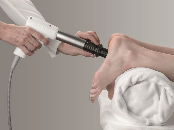 Behandlung der Ferse mit dem ASTAR Impactis M+ Stoßwellengerät in der Physiotherapie